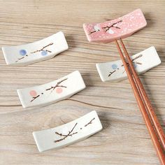 four chopsticks with designs on them sitting next to some chopsticks that have been placed in front of each other