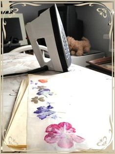 a computer monitor sitting on top of a desk next to a flowered table cloth