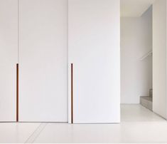 an empty room with white walls and cabinets