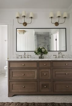 a bathroom with double sinks and two mirrors