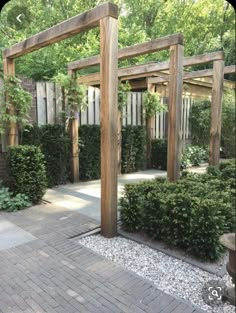 an outdoor garden with wooden pergols and stone walkway