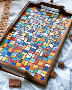 a tray that has been made out of colorful glass tiles on top of white cloth