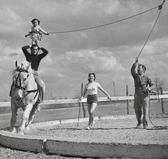 three people are riding horses while one person is holding onto the rope