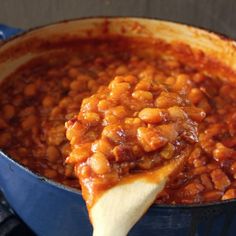 a spoon full of baked beans in a blue pot