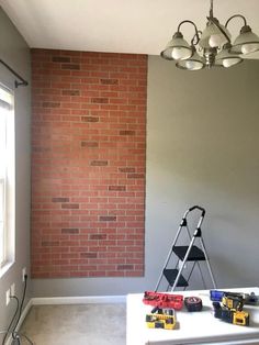 a room that has a ladder and some tools on it in front of a brick wall