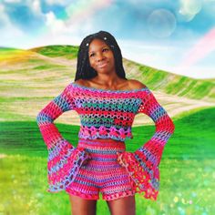 a woman in a crochet top and skirt posing for the camera with her hands on her hips