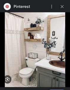 a white toilet sitting next to a sink in a bathroom under a mirror and wooden shelves