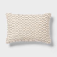 a beige and white checkered pillow on a gray background