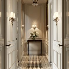 an elegant hallway with chandeliers and flowers on the table in between two doors