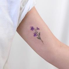 a woman's arm with purple flowers on it