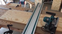 a table saw is being used to cut plywood planks with a power drill