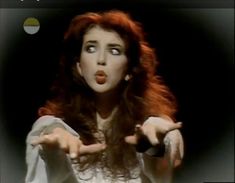 a woman with red hair is making a face and pointing her finger at the camera