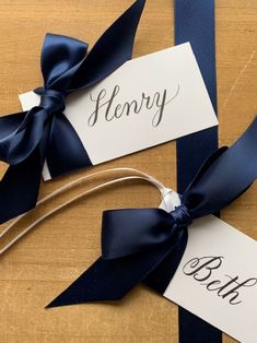 two name tags tied together with blue ribbon and twine on top of each other