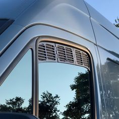 the side view mirror of a vehicle with trees in the background