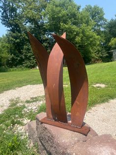 a large metal sculpture sitting on top of a rock