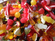 a bowl full of gummy bears and other candies in various shapes and colors