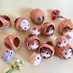 several small stuffed animals are sitting in their holes on the table next to some flowers