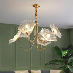 a chandelier hanging from the ceiling in a living room with green walls and furniture