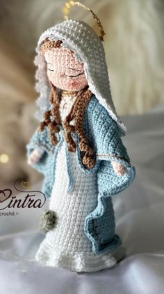 a crocheted doll is dressed in blue and white