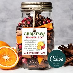 a glass jar filled with orange slices and cinnamons next to an orange slice on a table