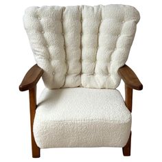 a white chair with a wooden frame and cushion on top of the armrests