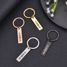 three metal key chains with two different types of keys on top of a black surface