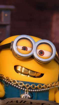 a yellow minion with big eyes and chains around it's neck holding a book