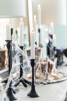 a table topped with candles and spider webs