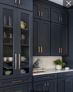 a kitchen with blue cabinets and white counter tops, gold pulls on the doors and brass handles