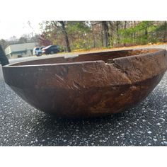 a large wooden bowl sitting on top of a road