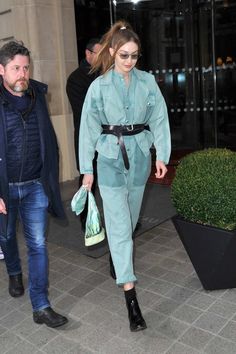 a woman walking down the street in a blue outfit