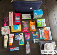 the contents of a travel bag laid out on top of a wooden table next to a blue purse