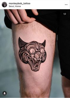 a tattoo on the leg of a man with an animal's head in black ink