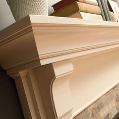 a close up of a fireplace with books on the mantle