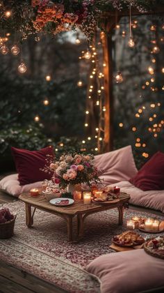 a table with candles, plates and flowers on it in the middle of a room