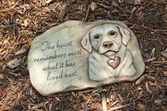 a stone with a dog's face on it that says, the heart remembers most what it has loved best