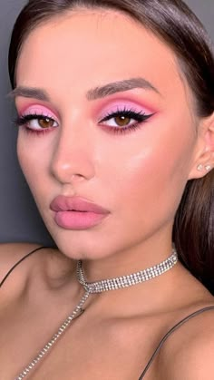 a woman with pink eyeshadow and choker on her neck posing for the camera