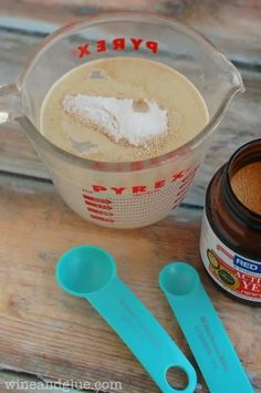 there are two measuring spoons next to a container with powder and sugar in it