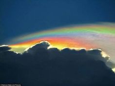 a rainbow in the sky above some clouds