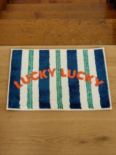 a blue and white rug with the words lucky lucky written on it in orange letters