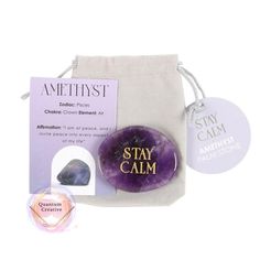 an amethyst stone with the words stay calm on it next to a tag