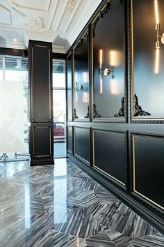 an elegantly decorated hallway with black walls and gold trim