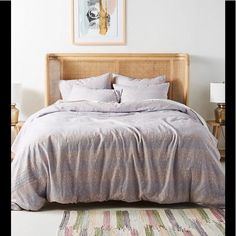 a bedroom with a bed, nightstands and pictures on the wall above it is shown