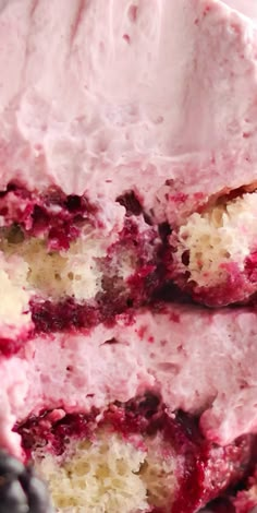 a close up of a piece of cake on a plate with blueberries and raspberry filling