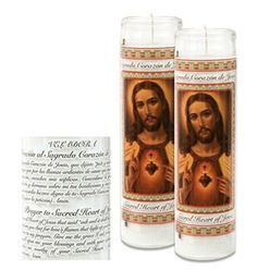 two candles with the image of jesus holding a heart in it and an inscription on each candle