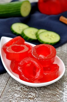 sliced cucumbers on a white plate next to other vegetables