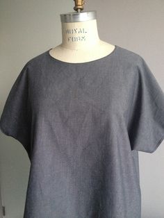 a mannequin is standing next to a gray shirt