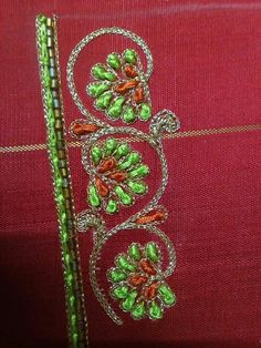 a red cloth with some green beads on it