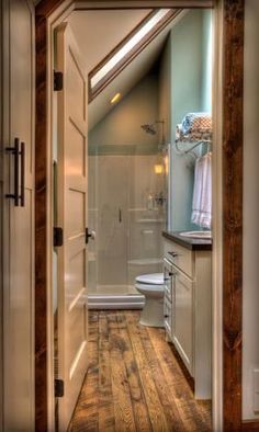 an open door leading to a bathroom with wooden floors