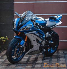 a blue and white yamaha motorcycle parked in front of a building